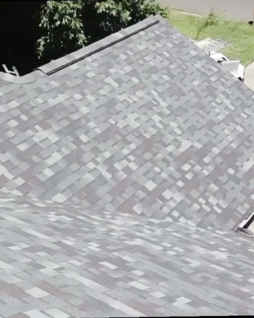 A completed Owens Corning Mountain Pine shingle roof, hip and valley lines running down to the driveway