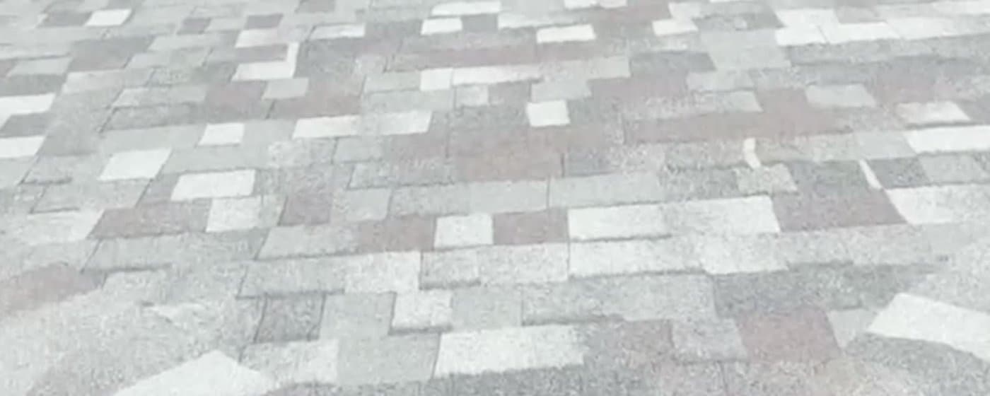 Close view of a freshly installed architectural asphalt shingle field showing the blended colour and staggered coursing
