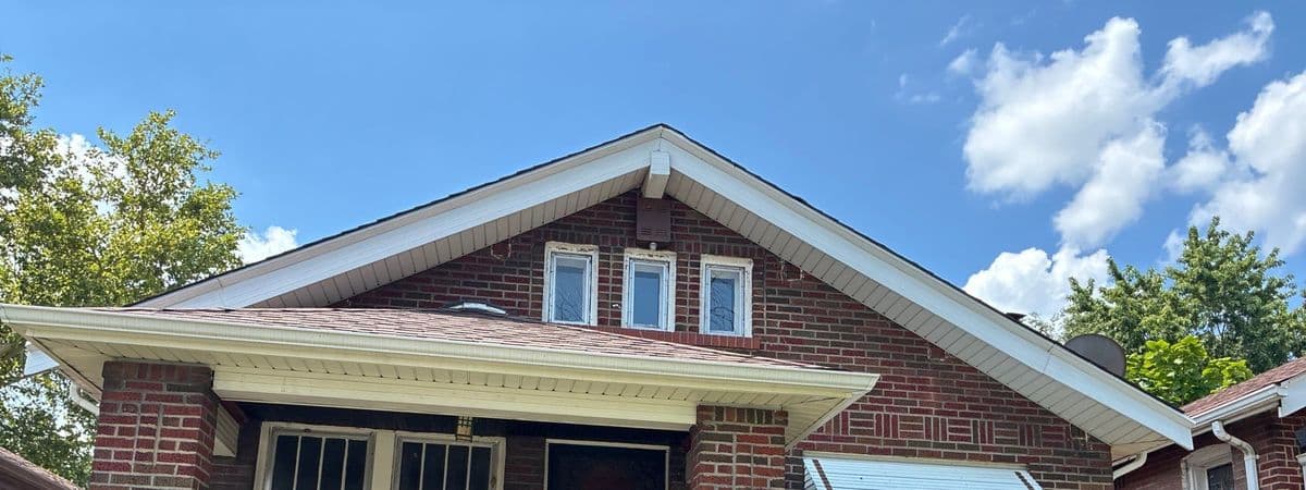 Front gable of a brick bungalow with the worn original roof still on the porch and main slope