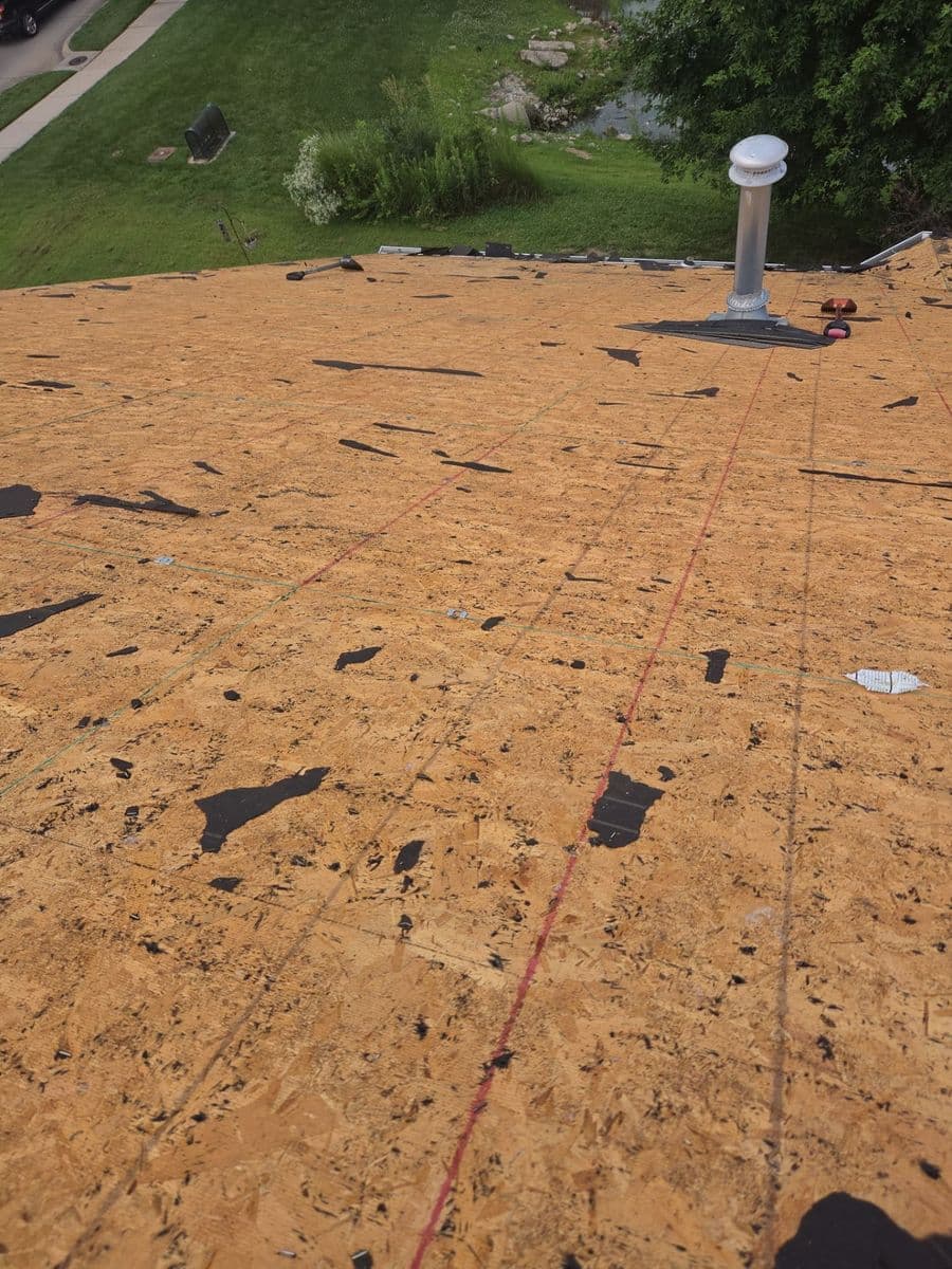 Roof stripped to bare decking mid-project, chalk lines snapped and a new vent stack set